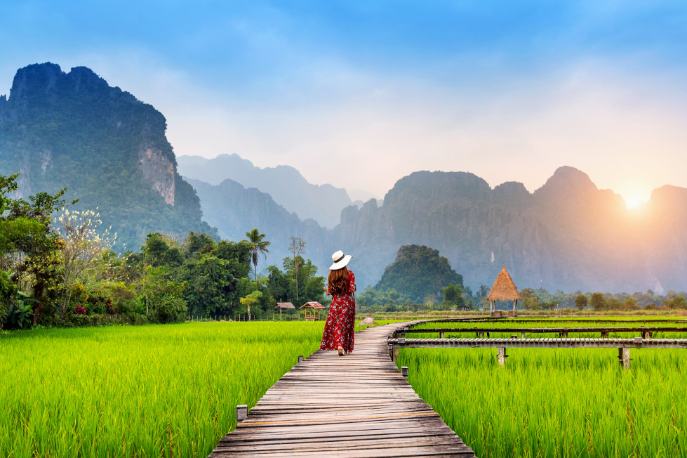 4... mujer joven caminando sendero madera campo arroz verde vang vieng laos (2)